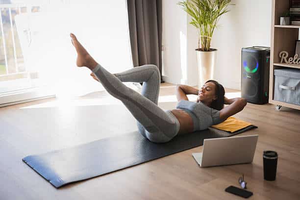 Female athlete exercising, doing abdomen exercises at home